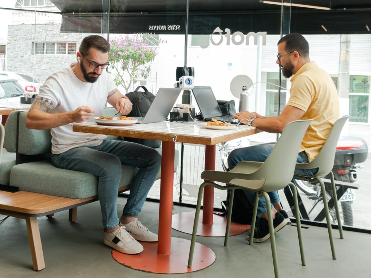 Ambiente industrial e descontraído da Unidade Galpão Selvagem, com mesa de trabalho compartilhada